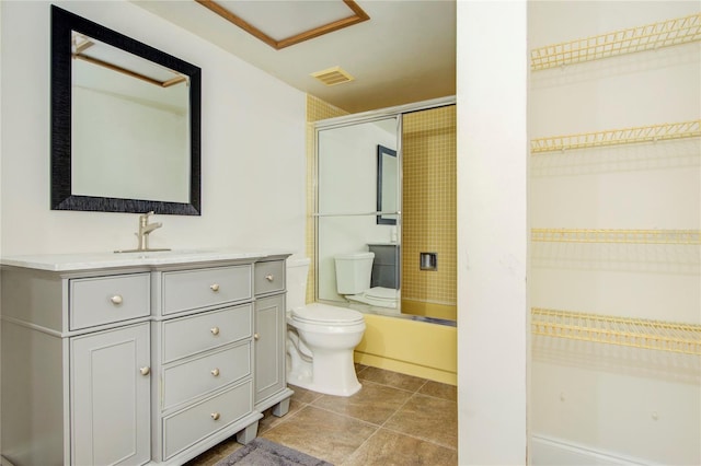 bathroom featuring tile patterned flooring, toilet, bath / shower combo with glass door, visible vents, and vanity