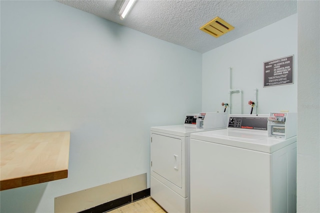 laundry area featuring a textured ceiling and separate washer and dryer