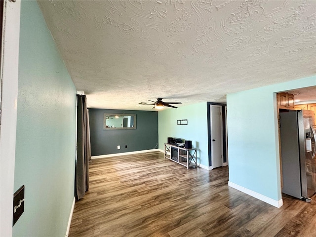 unfurnished living room featuring ceiling fan, a textured ceiling, and wood-type flooring