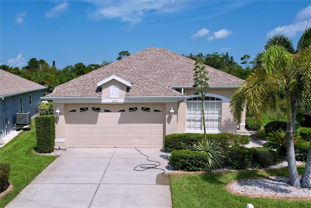 single story home featuring cooling unit and a garage