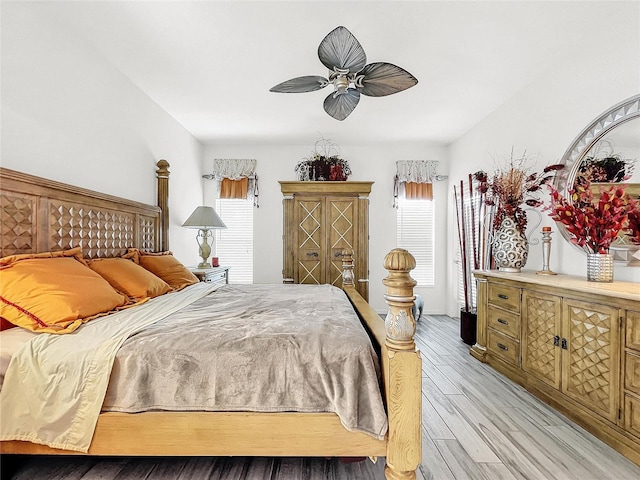 bedroom featuring ceiling fan, light wood-type flooring, and multiple windows