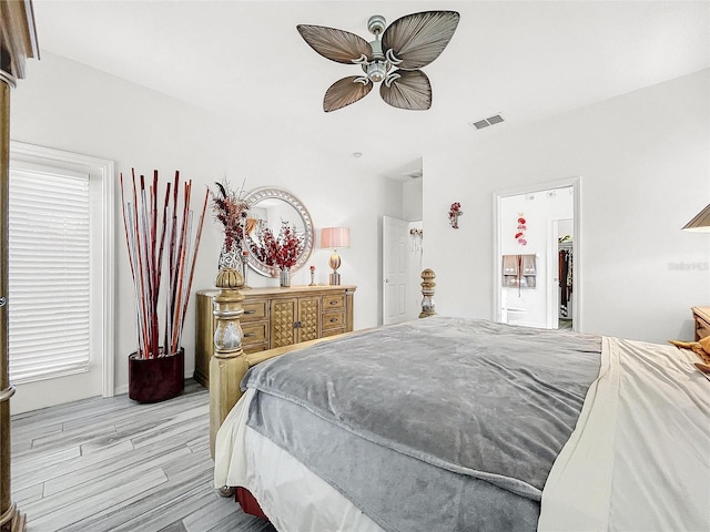 bedroom with a spacious closet, ceiling fan, and light hardwood / wood-style floors