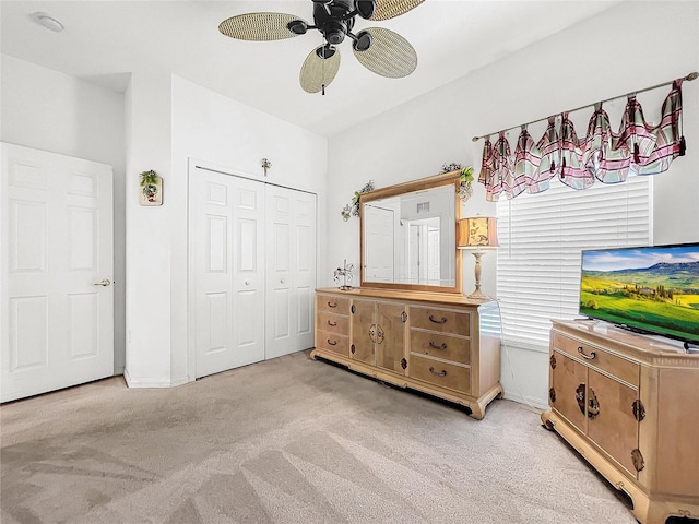 bedroom featuring ceiling fan, light colored carpet, and a closet