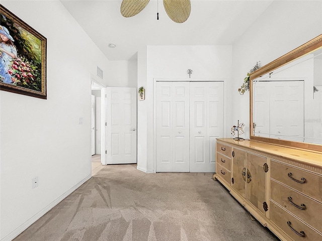 unfurnished bedroom featuring ceiling fan, a closet, and light carpet