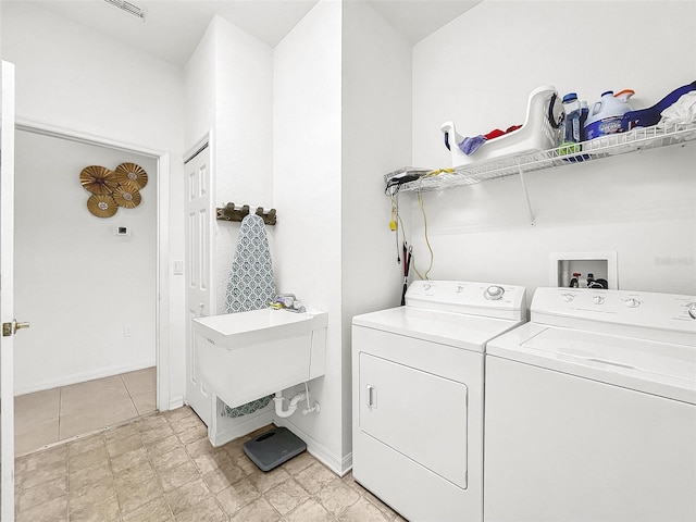 clothes washing area featuring separate washer and dryer and sink