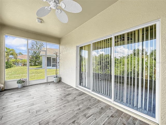 unfurnished sunroom with ceiling fan