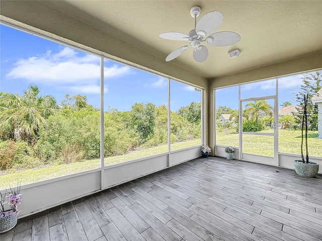 unfurnished sunroom with ceiling fan