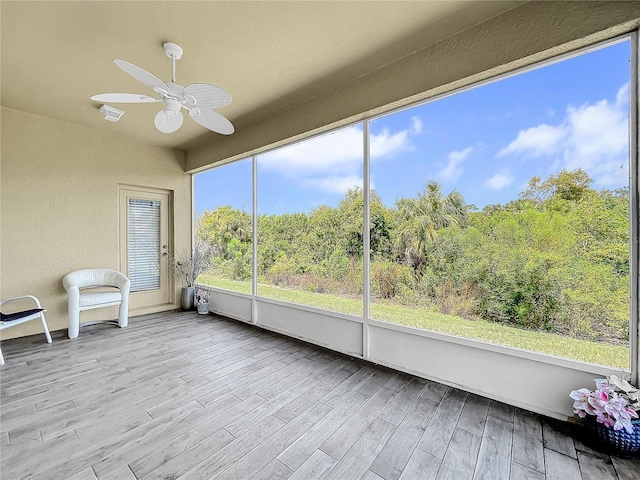 unfurnished sunroom featuring ceiling fan