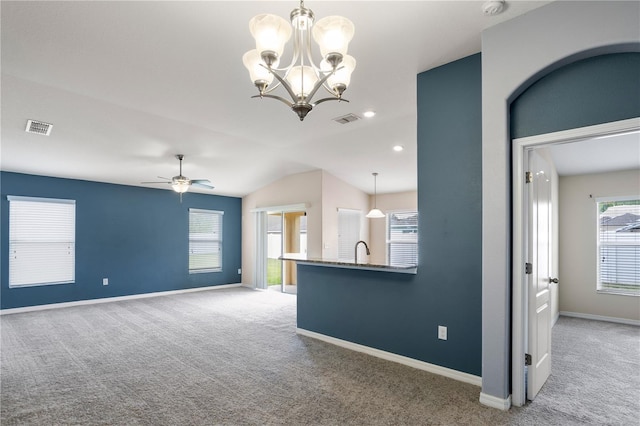 unfurnished living room with sink, carpet floors, lofted ceiling, and ceiling fan with notable chandelier