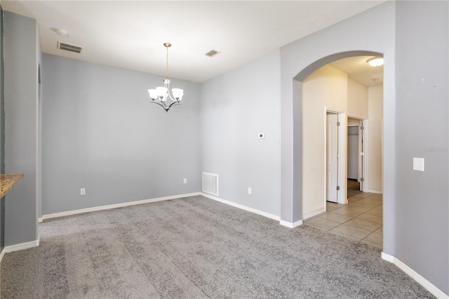 unfurnished room featuring light carpet and a chandelier