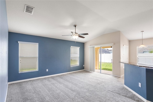 carpeted spare room with ceiling fan and vaulted ceiling