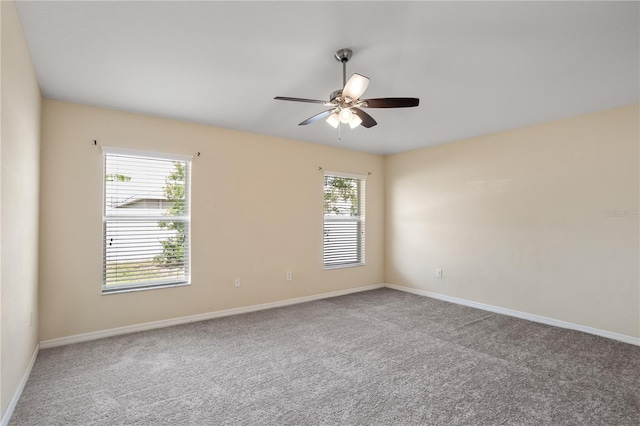 carpeted spare room featuring ceiling fan and a healthy amount of sunlight