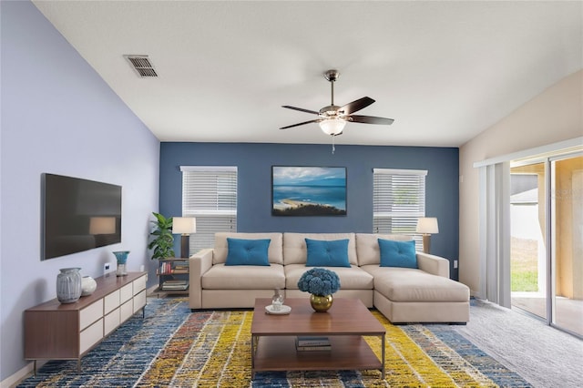 carpeted living room featuring ceiling fan and vaulted ceiling