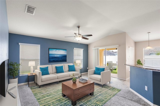 carpeted living room with ceiling fan and vaulted ceiling