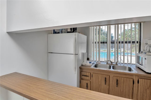 kitchen featuring white appliances and sink