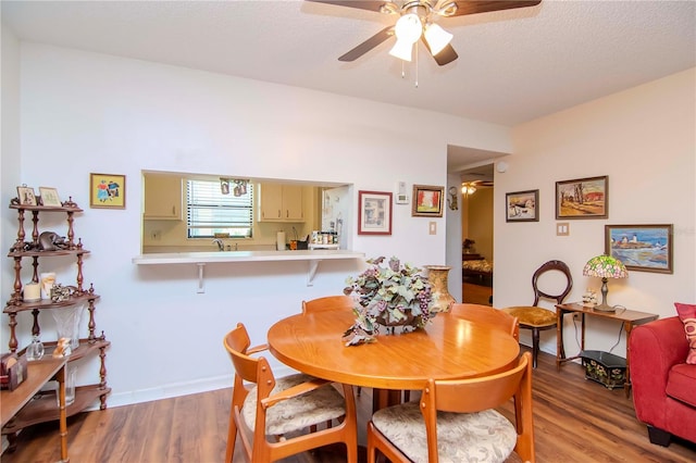 dining room with hardwood / wood-style flooring, a textured ceiling, and ceiling fan