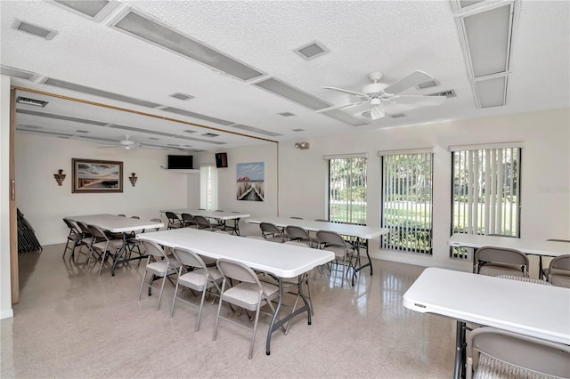 dining area with ceiling fan and a textured ceiling