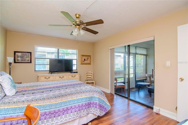 bedroom with multiple windows, hardwood / wood-style floors, a textured ceiling, and ceiling fan