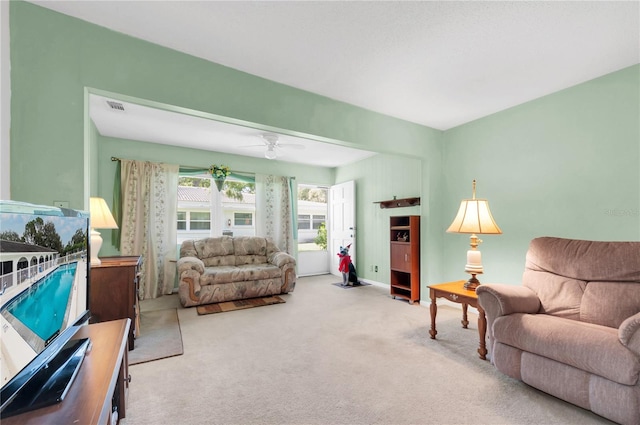 carpeted living room with ceiling fan