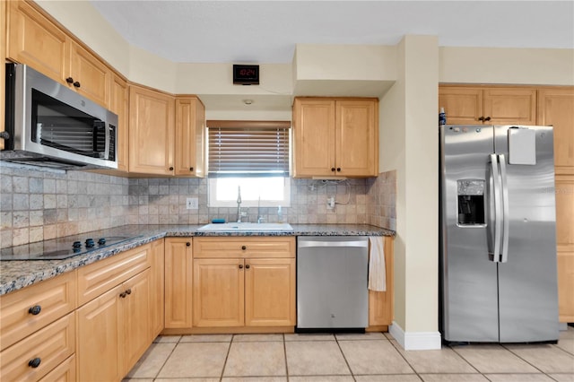 kitchen with decorative backsplash, light tile patterned floors, sink, stone counters, and stainless steel appliances