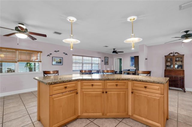 kitchen with light tile patterned floors, plenty of natural light, and a kitchen island