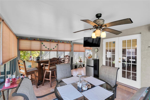 tiled dining space featuring ceiling fan and french doors