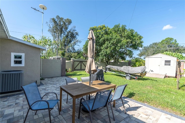 view of patio with central AC unit and an outbuilding