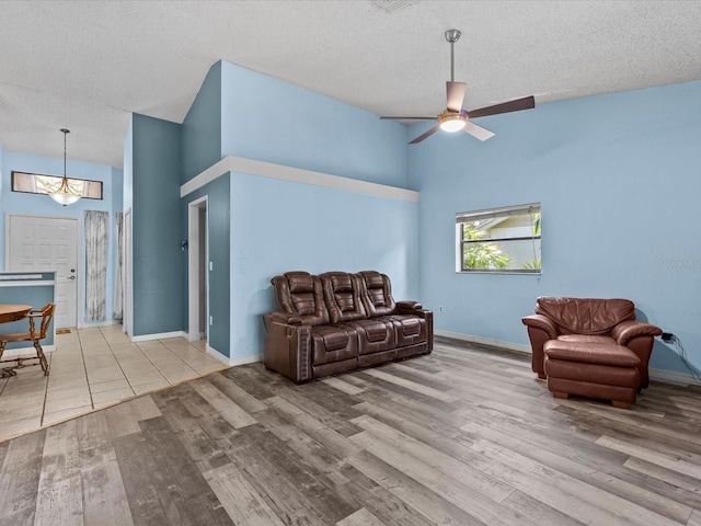 sitting room featuring a textured ceiling, high vaulted ceiling, and light wood-type flooring