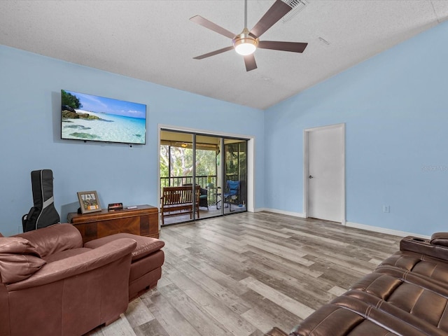 living room with ceiling fan, light hardwood / wood-style flooring, lofted ceiling, and a textured ceiling