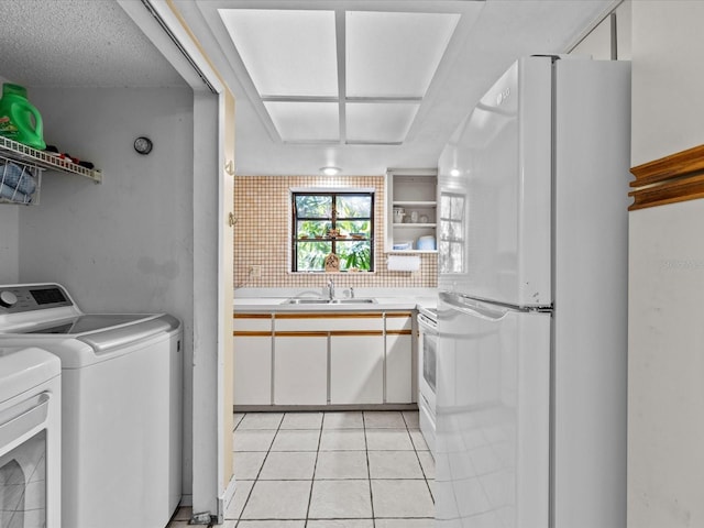 laundry area with sink, light tile patterned flooring, and independent washer and dryer