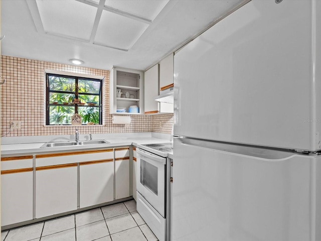 kitchen featuring light tile patterned flooring, sink, white appliances, tasteful backsplash, and white cabinets