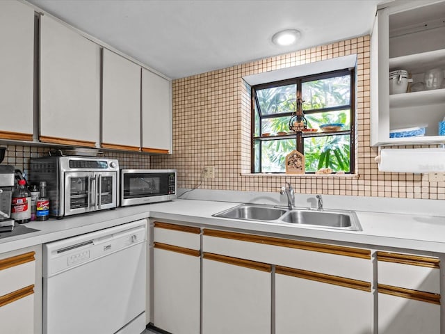 kitchen featuring sink, white cabinetry, white dishwasher, and tasteful backsplash