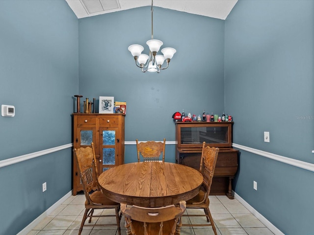 tiled dining space featuring a chandelier and lofted ceiling