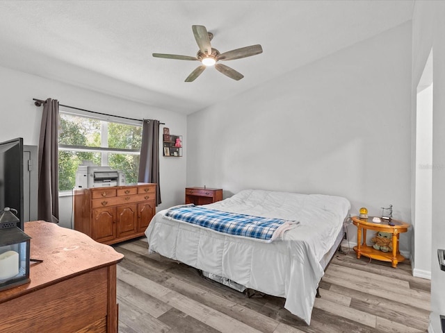 bedroom with ceiling fan, lofted ceiling, and hardwood / wood-style floors