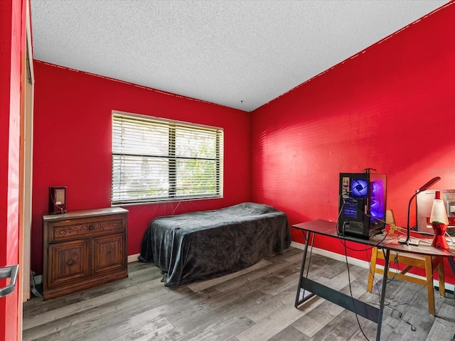 bedroom with light wood-type flooring and a textured ceiling