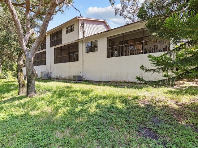 view of side of home featuring a yard and central AC