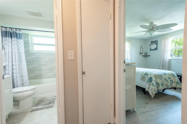 bathroom with toilet, ceiling fan, hardwood / wood-style flooring, and shower / bathtub combination with curtain