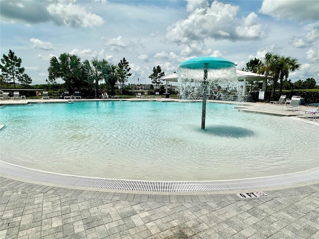 view of swimming pool with pool water feature