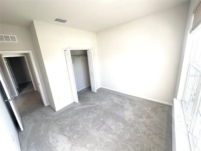 unfurnished bedroom featuring dark carpet and a closet