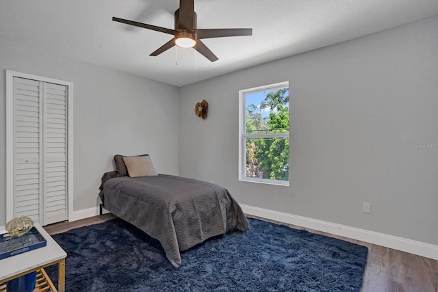 bedroom featuring a closet, dark hardwood / wood-style floors, and ceiling fan