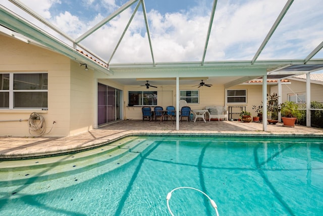 outdoor pool with glass enclosure, a patio, and ceiling fan