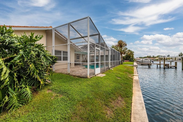 dock area featuring a patio, glass enclosure, a water view, a yard, and an outdoor pool