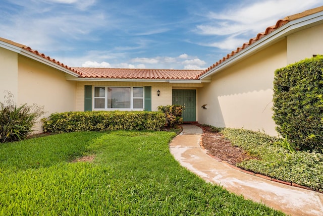 view of exterior entry with a yard