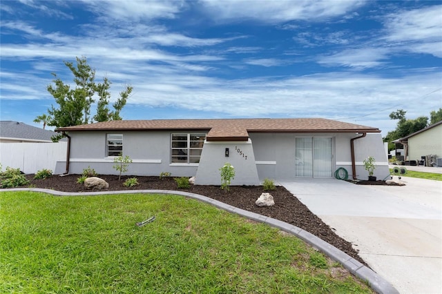 ranch-style home featuring a shingled roof, a front lawn, and stucco siding