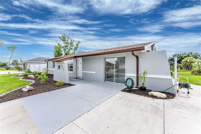 rear view of property featuring stucco siding