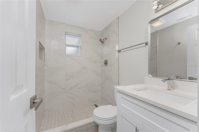 full bathroom featuring vanity, toilet, and a tile shower