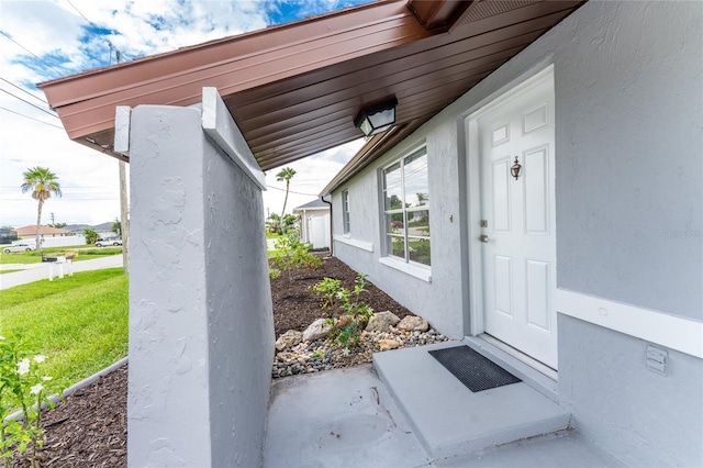 property entrance with a lawn