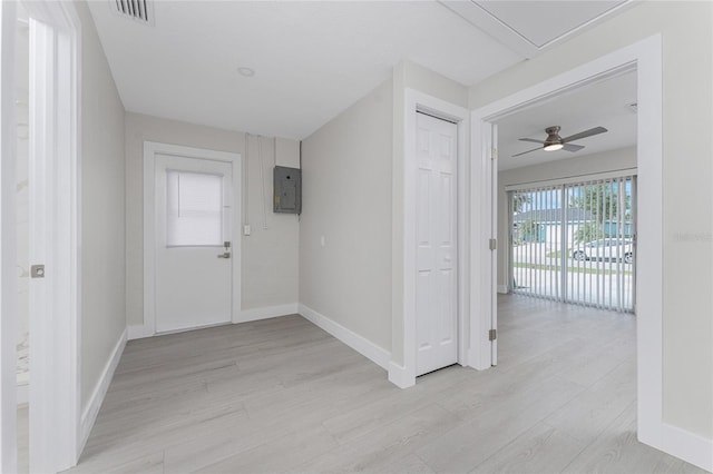 foyer entrance featuring electric panel, visible vents, light wood-style flooring, and baseboards