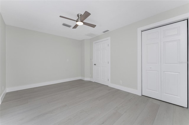 unfurnished bedroom with ceiling fan, light wood-style floors, visible vents, and baseboards