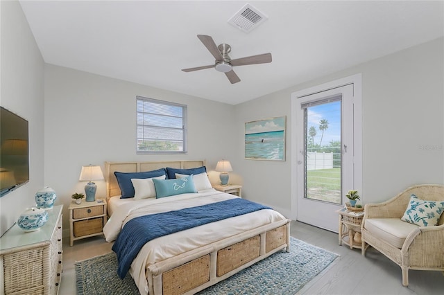 bedroom with access to outside, multiple windows, visible vents, and light wood finished floors